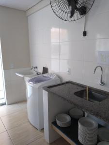 uma casa de banho com um lavatório e um balcão com placas em Pousada Batista em Itapema