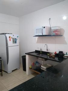 uma cozinha com um frigorífico branco e um lavatório em Pousada Batista em Itapema