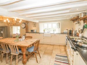 a large kitchen with a wooden table and chairs at Langstone Farm in Okehampton