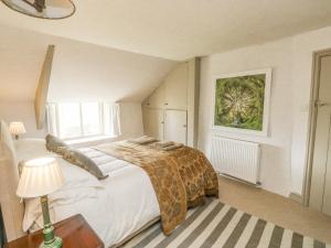 a bedroom with a large bed and a table with a lamp at Langstone Farm in Okehampton