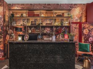 - un bar dans une pièce dotée d'un mur d'étagères dans l'établissement Hôtel Brittany, à Paris