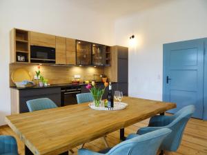 une salle à manger avec une table en bois et des chaises bleues dans l'établissement Gut Grasleiten, à Huglfing