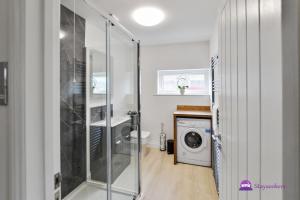 a bathroom with a shower and a washing machine at Annie 1 bed Apartment next to rail station - STAYSEEKERS in Salisbury