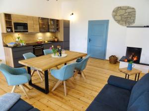 kuchnia i salon z drewnianym stołem i krzesłami w obiekcie Gut Grasleiten w mieście Huglfing