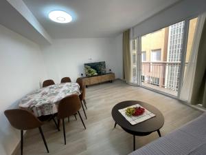 a dining room with a table and chairs and a room with a view at Gran apartamento diseño in Alicante
