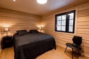 a bedroom with a bed and a chair in a room at Villa Levilla, luxury in Levi in Levi
