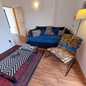 uma sala de estar com um sofá azul e duas cadeiras em Seaview em Ljubac