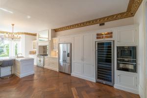 uma cozinha com armários brancos e piso em madeira em Luxury Villa - City Centre - Sleeps 13 em Nottingham