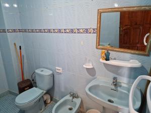 a bathroom with a toilet and a sink and a mirror at Large Family Apartment by Beach & center of town in Asilah