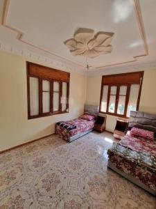 a large room with two beds and a ceiling at Large Family Apartment by Beach & center of town in Asilah
