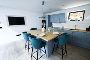 a kitchen with a wooden table and blue chairs at Emery Street Lodge in Cambridge