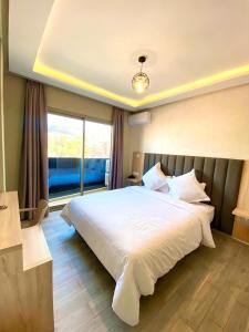 a bedroom with a large bed and a large window at HOTEL PALACE AL SALAM , Beni Mellal in Beni Mellal