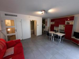 ein Wohnzimmer mit einem roten Sofa und einem Tisch in der Unterkunft Appartement Bayonne, 1 pièce, 2 personnes - FR-1-239-906 in Bayonne