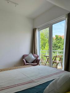 - une chambre avec un lit et une grande fenêtre dans l'établissement LEYLA Apartments, à Nido