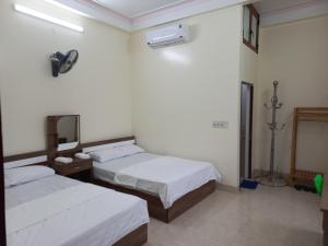 - une chambre avec 2 lits et un miroir mural dans l'établissement Homestay Quyết Thương, à Cao Bằng