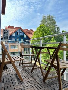 Elle comprend un balcon avec une table et des chaises en bois. dans l'établissement LEYLA Apartments, à Nido
