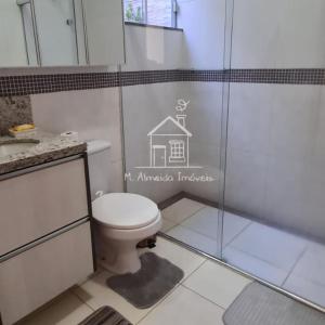 uma casa de banho com um WC e uma cabina de duche em vidro. em Casa Jardim Itália II em Maringá