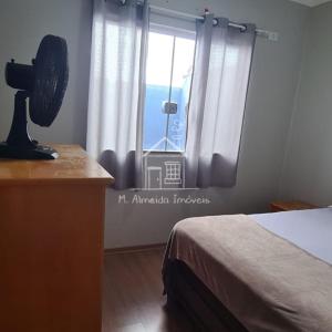 um quarto com uma cama e uma janela com o oceano em Casa Jardim Itália II em Maringá