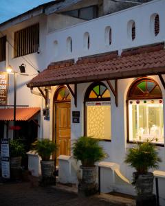 un edificio con macetas delante de una puerta en New Old Dutch House - Galle Fort, en Galle