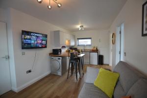 a living room with a couch and a kitchen at Annie 1 bed Apartment next to rail station - STAYSEEKERS in Salisbury