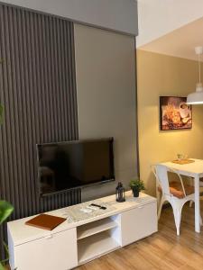 ein Wohnzimmer mit einem TV und einem weißen Tisch in der Unterkunft 81 Newport C5 10i Balcony & Pool across NAIA T3 in Manila