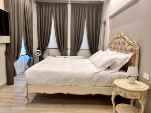 a bedroom with a large white bed with a large window at Villa Nonna Cicci Boutique Hotel - SPA in Cisterna dʼAsti