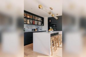 a kitchen with a white island and bar stools at Villa Horizonte - Biarritz in Biarritz +27 photos