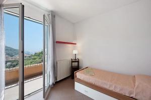 a bedroom with a bed and a large window at Bagetti in Varazze