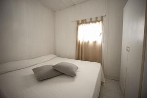 una camera da letto con un letto bianco e un cuscino sopra di Villaggio Campeggio Nettuno di Paestum a Paestum