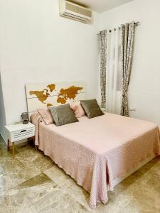 1 dormitorio con 1 cama con manta rosa en Apartamento acogedor y moderno en pleno centro de Sevilla con Parking Gratis, en Sevilla