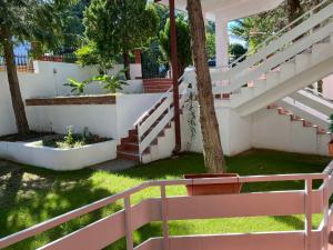 a white staircase in a yard with a tree at Aqualux Apartments in Star Dojran