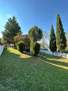 a park with a fence and trees and grass at Aqualux Apartments in Star Dojran