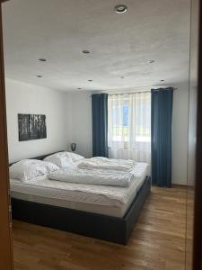 a bedroom with a large bed with blue curtains at One Bedroom Apartment with Panoramic views in Piesendorf