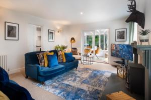 a living room with a blue couch and a fireplace at Bellfoot Rural Retreat and Hot Tub in Grasmere
