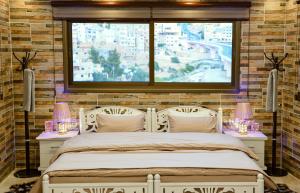 a bedroom with a bed with two lamps and a window at PETRA ROYAL HOUSE in Wadi Musa