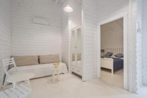Dormitorio blanco con cama, mesa y silla en Casa Blanca Olimp, en Olimp