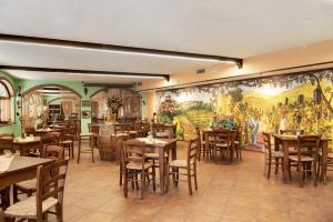 un ristorante con tavoli, sedie e un murale di Magnolia a Cisterna dʼAsti