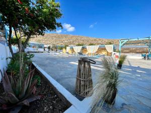 a parking lot with chairs and a trash can at Family Villages Santorini in Vlychada Beach