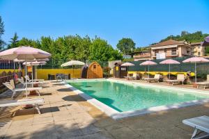 - une piscine avec des tables, des parasols et des chaises dans l'établissement Magnolia, à Cisterna dʼAsti