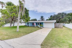 a house with a palm tree and a driveway at Pet-Friendly Cocoa Beach Vacation Rental! in Cocoa Beach