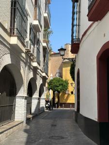 un callejón en una ciudad con edificios y una calle en Apartamento acogedor y moderno en pleno centro de Sevilla con Parking Gratis, en Sevilla