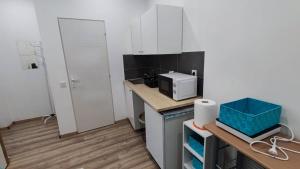 een kleine keuken met witte kasten en een magnetron bij Mini apartman in the central in Boedapest