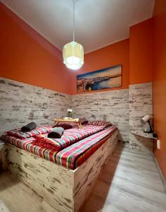 un grande letto in una stanza con pareti arancioni di Flower house 1 a Sofia