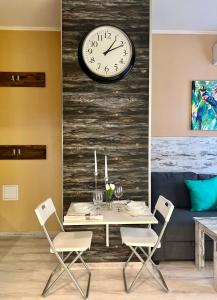 a dining room with a table and a clock on a wall at Flower house 1 in Sofia