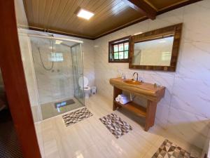 y baño con lavabo y ducha. en Pousada Vale da Represa, en Visconde De Maua