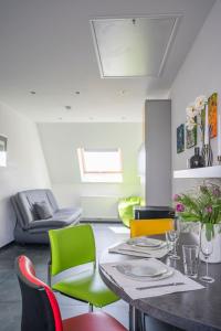 uma sala de estar com uma mesa e cadeiras coloridas em Ferienwohnung Die Himmlische em Kleve