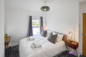 a bedroom with a white bed with towels on it at Thomas 1 bed Apartment with cathedral views - STAYSEEKERS in Salisbury