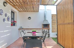 a patio with a table and chairs and a stove at Chalet Isla Papua in Chiclana de la Frontera