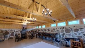 a large room with a stone wall with a table and chairs at Vakari Puhketalu in Vakari