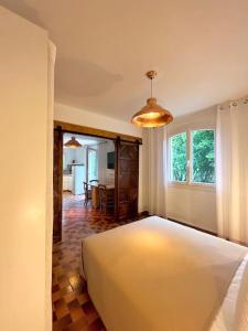 um quarto com uma cama grande e uma sala de jantar em Gite Harmonie em Gréoux-les-Bains